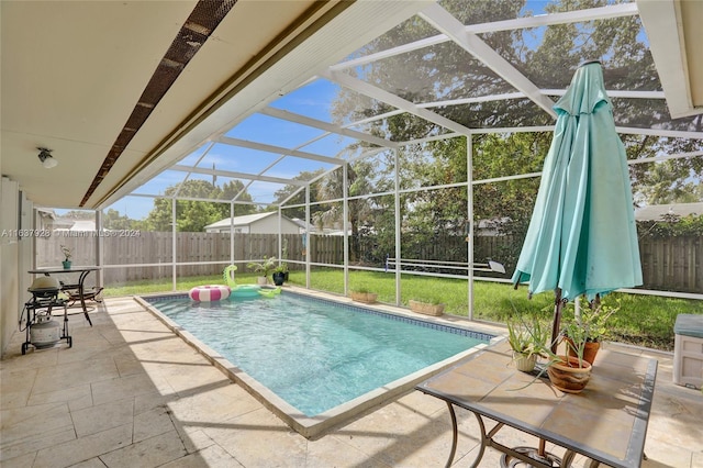 view of swimming pool with glass enclosure and a patio area