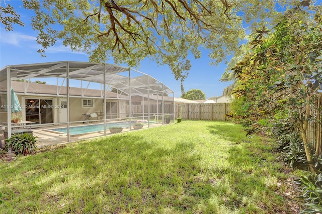 view of yard with a lanai and a fenced in pool