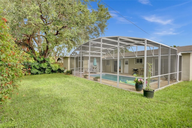 rear view of house featuring a lanai and a yard