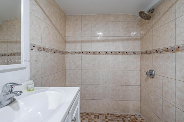 bathroom featuring a tile shower and vanity