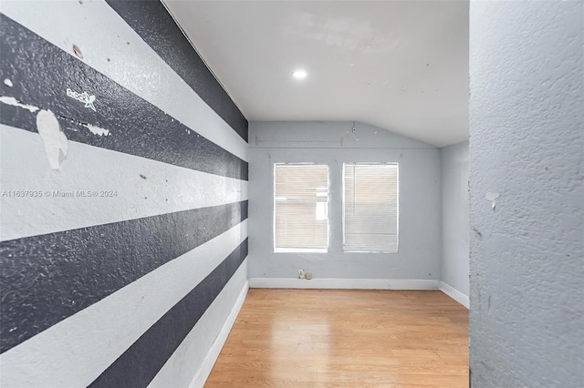 unfurnished room with light hardwood / wood-style flooring and lofted ceiling