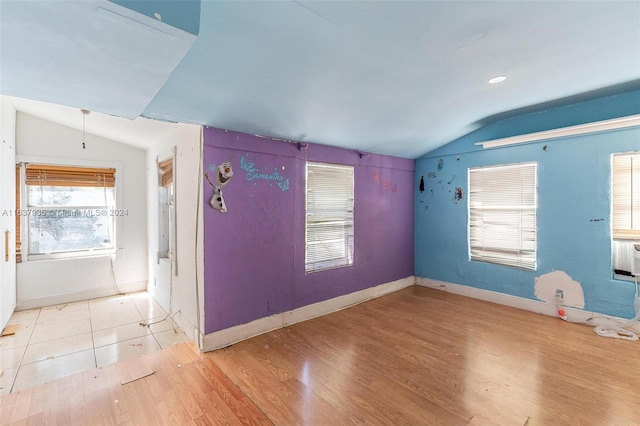 unfurnished room with light hardwood / wood-style floors and vaulted ceiling