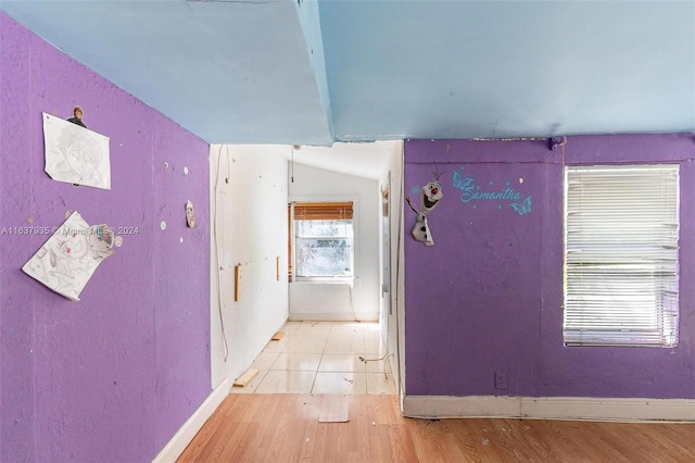 corridor featuring light hardwood / wood-style flooring and lofted ceiling