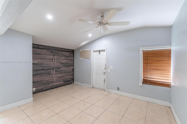 empty room featuring ceiling fan, light tile patterned floors, and lofted ceiling