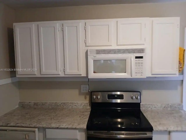 kitchen featuring white cabinetry, light stone countertops, and electric stove