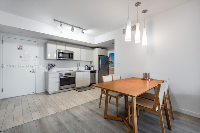 dining room with track lighting and light hardwood / wood-style floors