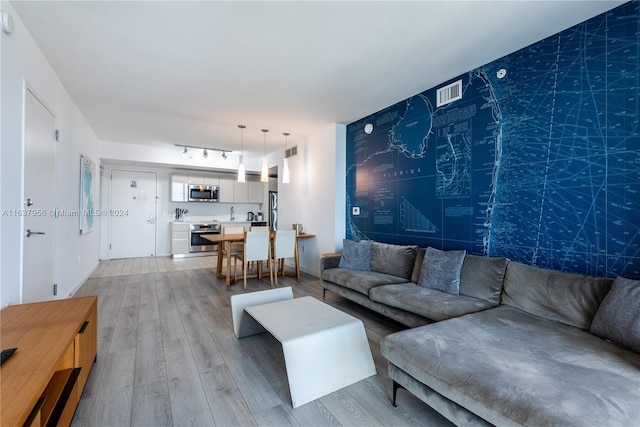 living room with track lighting and light wood-type flooring