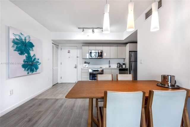 kitchen featuring visible vents, baseboards, appliances with stainless steel finishes, wood finished floors, and white cabinetry