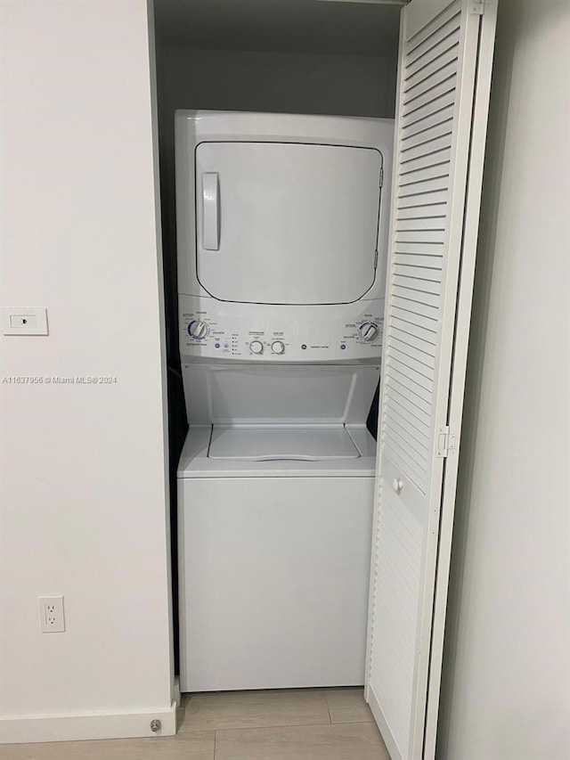 washroom featuring light hardwood / wood-style flooring and stacked washer and clothes dryer