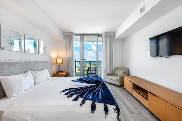 bedroom featuring floor to ceiling windows and light wood-type flooring