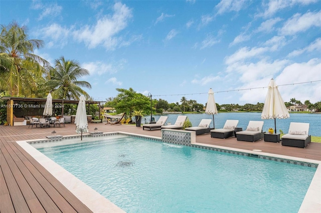 view of pool with a patio, outdoor lounge area, a water view, and pool water feature