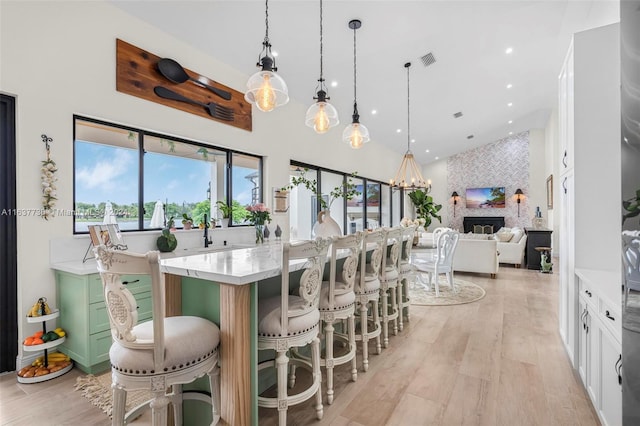 kitchen with white cabinetry, decorative light fixtures, and a breakfast bar area