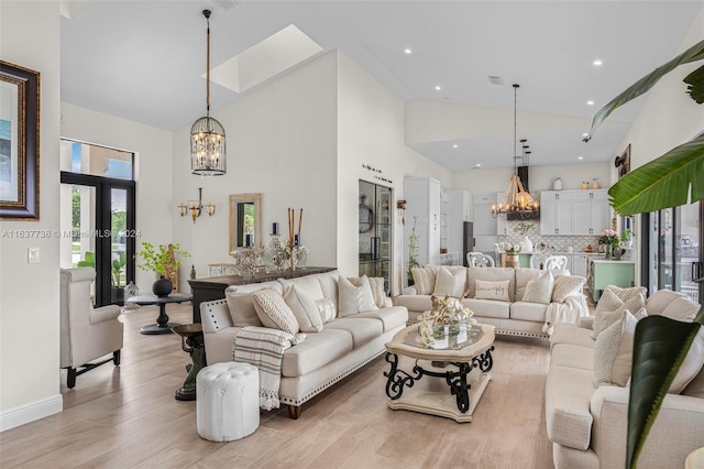 living room with light hardwood / wood-style floors and high vaulted ceiling