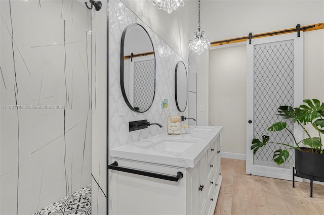 bathroom featuring vanity, a notable chandelier, hardwood / wood-style floors, and tiled shower