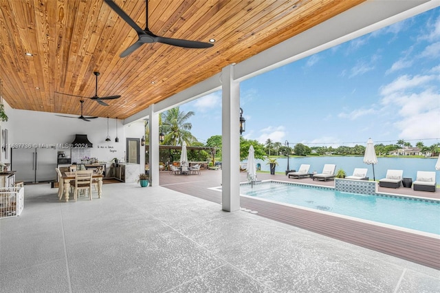 view of pool with outdoor lounge area, a water view, a patio, and ceiling fan