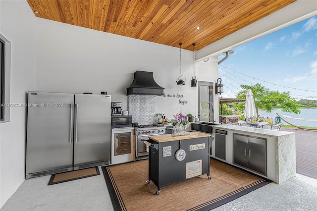 kitchen with premium appliances, sink, a center island, hanging light fixtures, and custom range hood