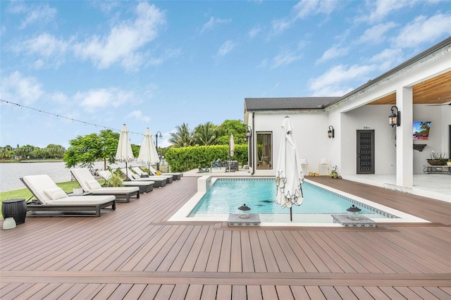 view of pool featuring a patio area and a wooden deck