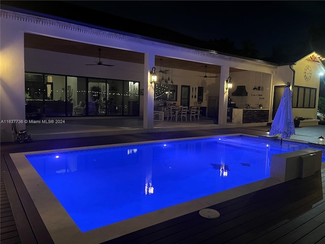 pool at twilight featuring a patio area and ceiling fan