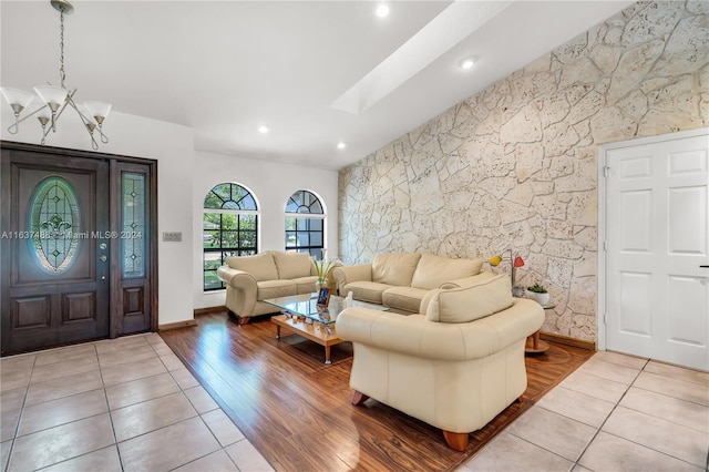 living room featuring a skylight, light hardwood / wood-style flooring, and a chandelier