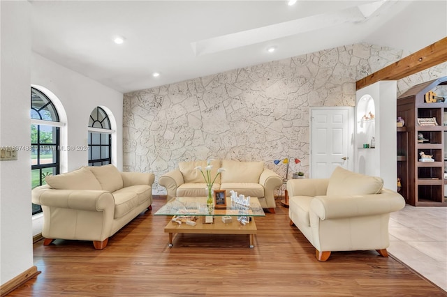 living room with lofted ceiling with skylight and light hardwood / wood-style flooring