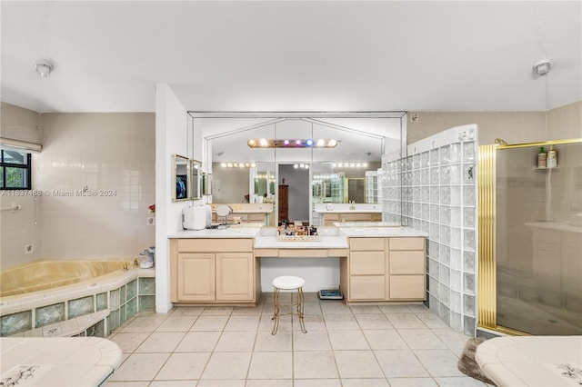 bathroom featuring shower with separate bathtub, vanity, tile patterned floors, and tile walls