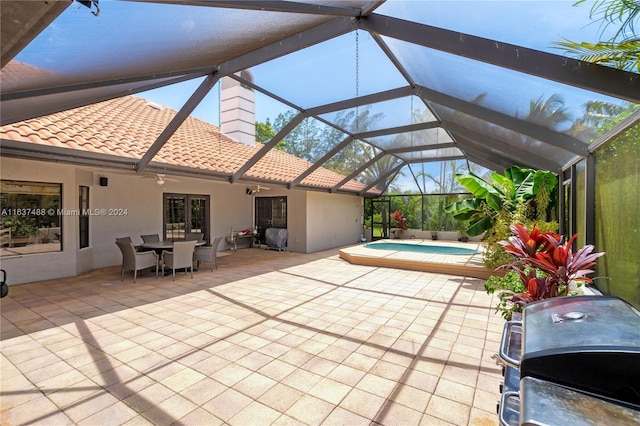 view of patio / terrace featuring glass enclosure, ceiling fan, and grilling area