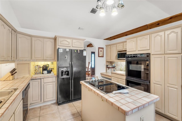 kitchen with tile counters, light tile patterned floors, decorative backsplash, a kitchen island, and black appliances