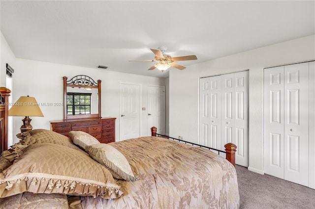 bedroom featuring carpet, ceiling fan, and two closets