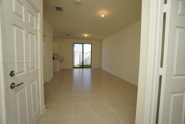 spare room with light tile patterned floors, visible vents, and baseboards