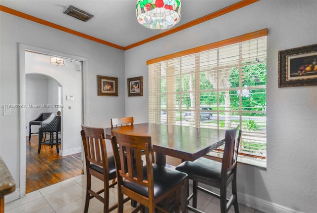 dining area with light tile patterned floors and ornamental molding