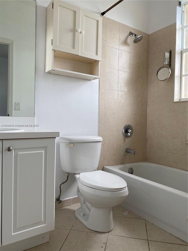 full bathroom featuring toilet, tiled shower / bath combo, vanity, tile patterned floors, and plenty of natural light