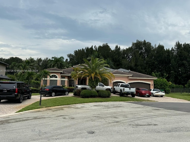 single story home with a garage and a front lawn