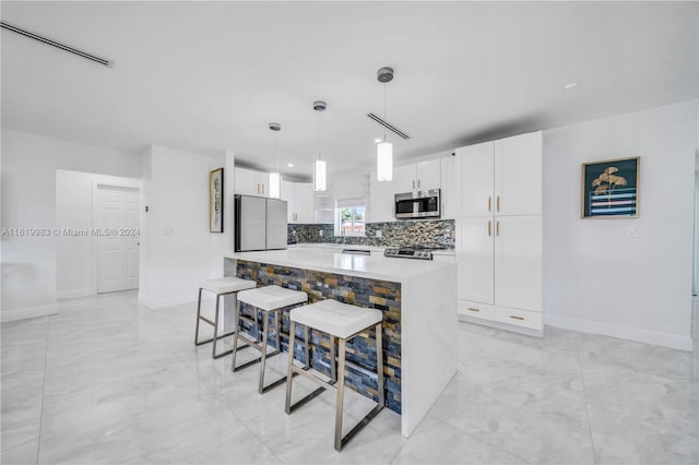 kitchen with refrigerator, white cabinets, a kitchen island, and backsplash