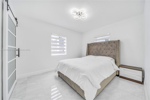 bedroom featuring a barn door and light tile patterned floors