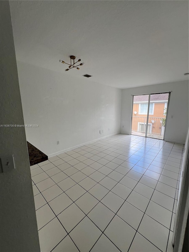 spare room with ceiling fan and light tile patterned flooring