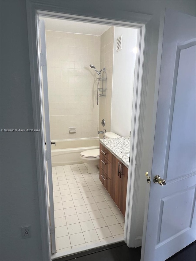 full bathroom with tiled shower / bath combo, vanity, toilet, and tile patterned floors