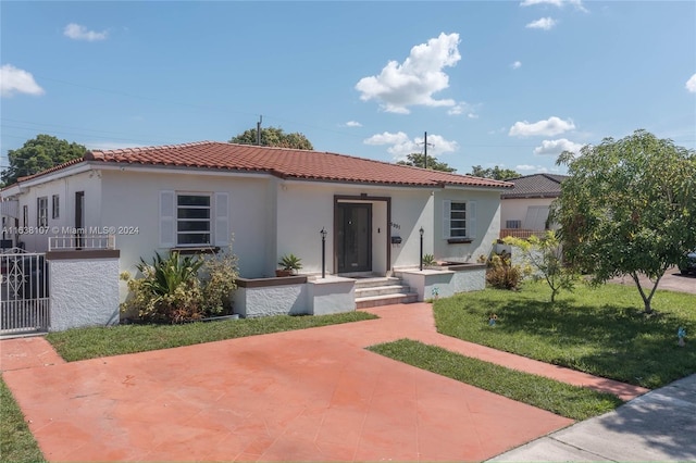 mediterranean / spanish house with a front lawn