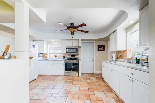 kitchen featuring ceiling fan, sink, white cabinets, and appliances with stainless steel finishes