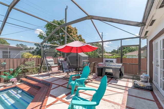 view of patio featuring area for grilling, glass enclosure, a storage unit, and a swimming pool