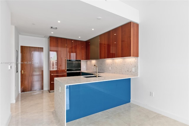 kitchen with sink, light tile patterned flooring, black double oven, and tasteful backsplash