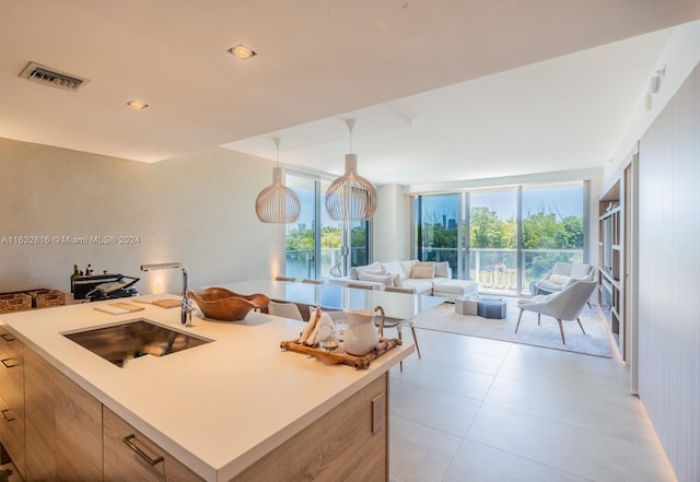 kitchen featuring light tile patterned floors, sink, a kitchen island, and hanging light fixtures