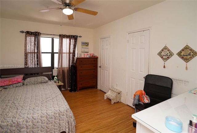 bedroom with multiple closets, ceiling fan, and hardwood / wood-style floors