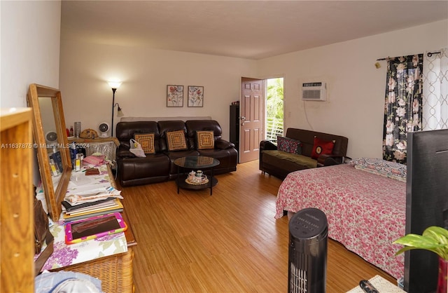 bedroom with a wall mounted AC and light wood-type flooring