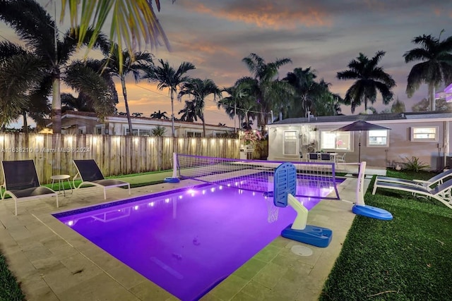 pool at dusk featuring a patio