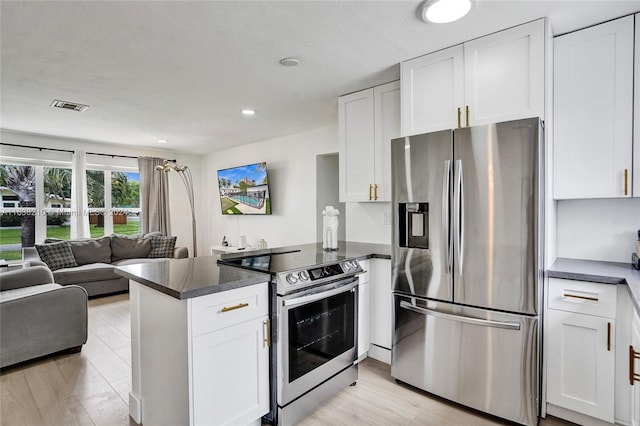 kitchen with appliances with stainless steel finishes, light wood-type flooring, kitchen peninsula, and white cabinetry