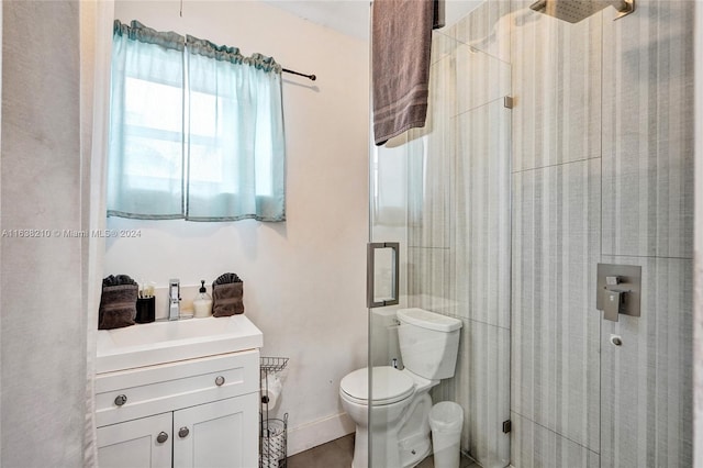 bathroom featuring a shower with shower door, toilet, and vanity