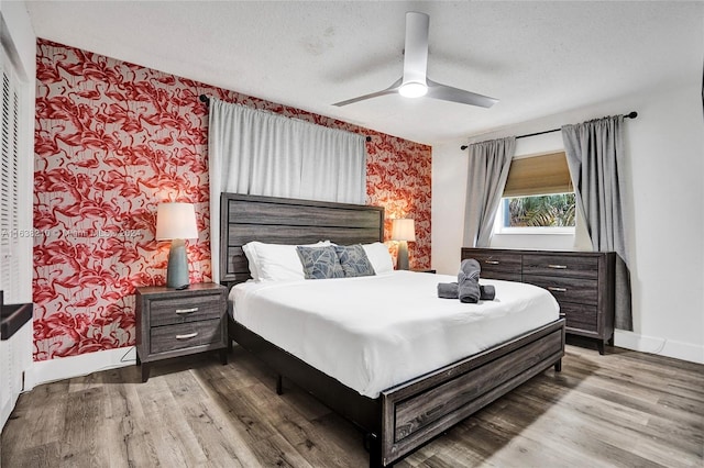 bedroom featuring a textured ceiling, wood-type flooring, and ceiling fan