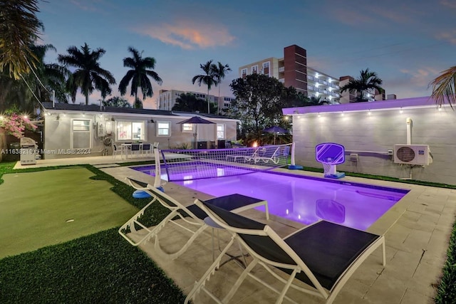 pool at dusk featuring a patio area