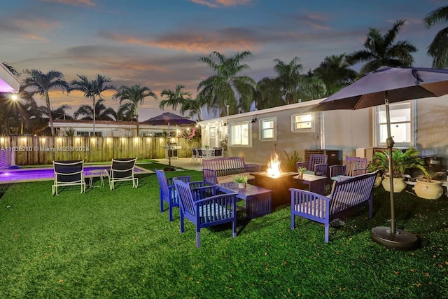 yard at dusk featuring an outdoor fire pit