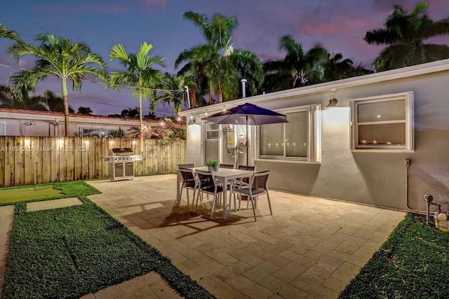 patio terrace at dusk featuring grilling area